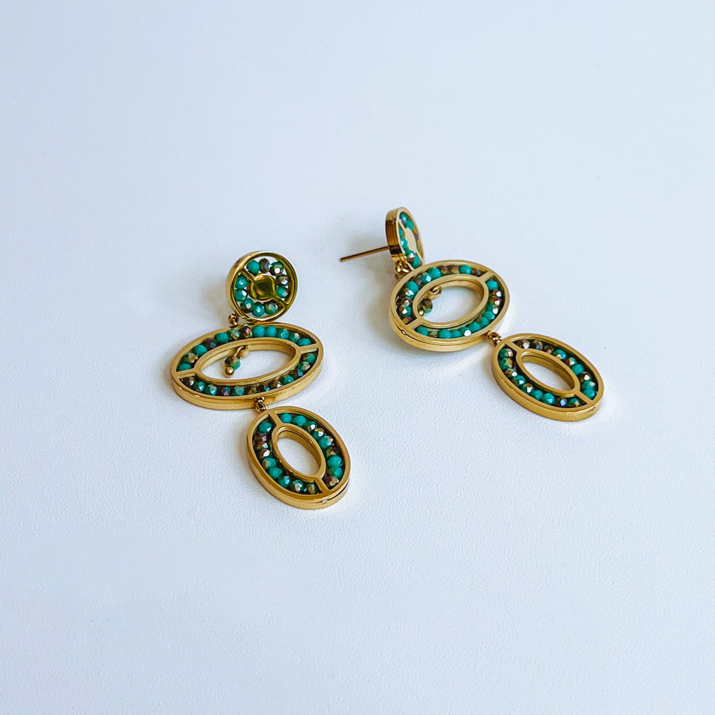 Abaco Earrings - Aquamarine Gold earrings with green turquoise gemstones on a light background