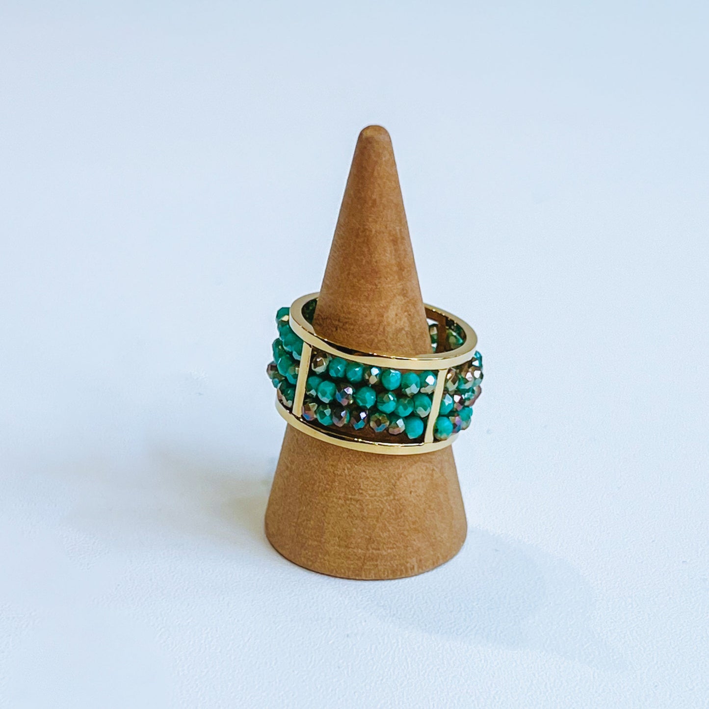 Abaco Ring - Aquamarine gold green gems rings on a wooden stand against a light background