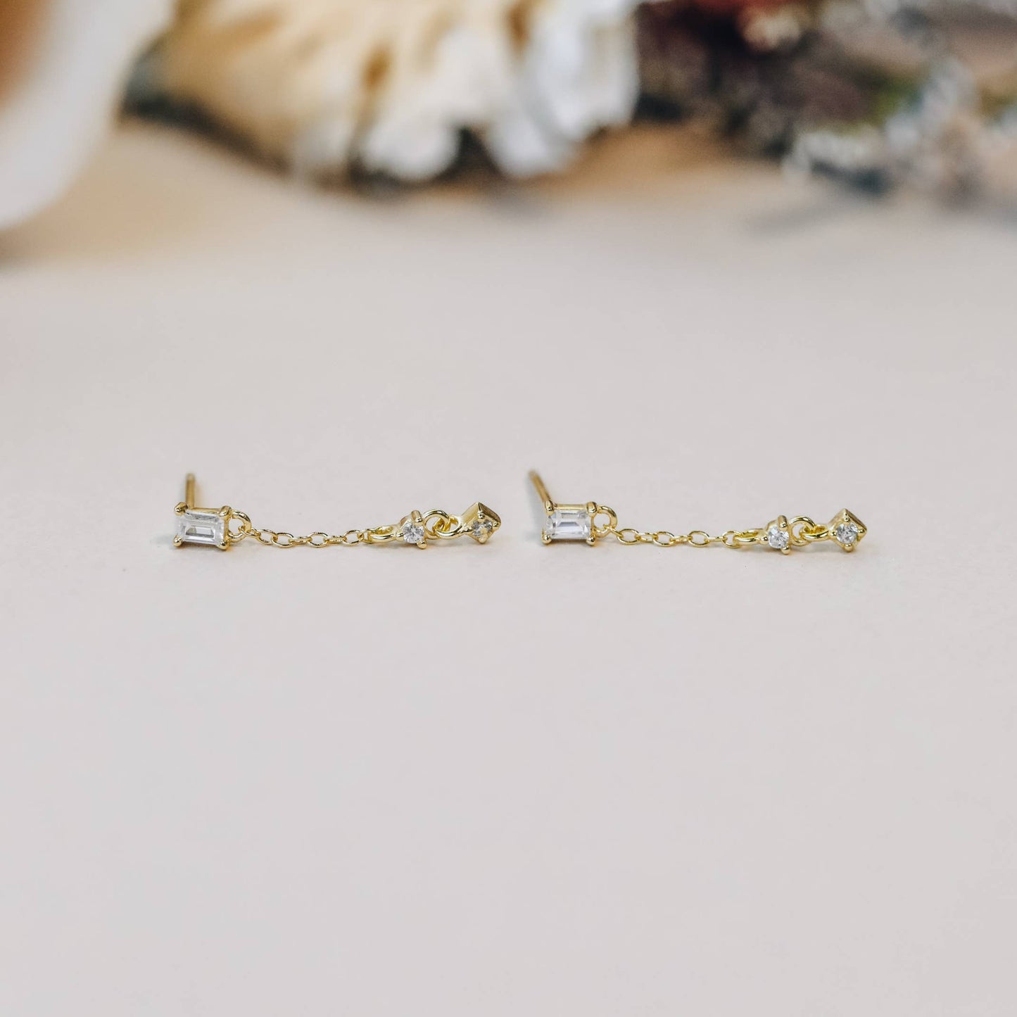 Baguette Drop Earrings - White Gold earrings with small clear diamonds on a light blurred surface