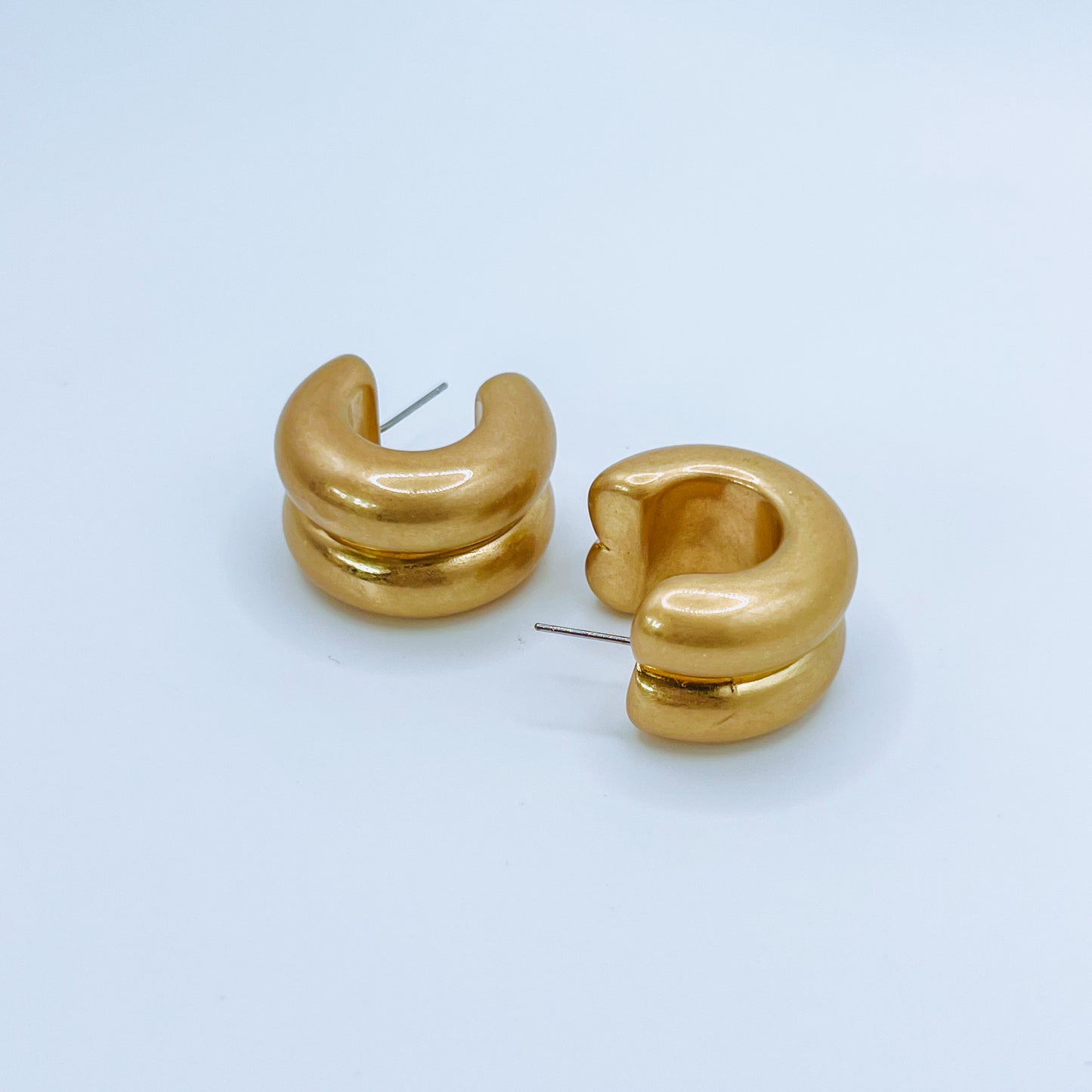 Chunky Gold Hoop Earrings Pair of gold hoop earrings on a background