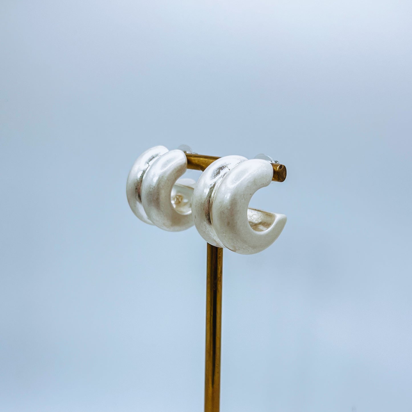 Chunky Silver Hoop Earrings Pair of silver hoop earrings on jewelry stand on a clear background