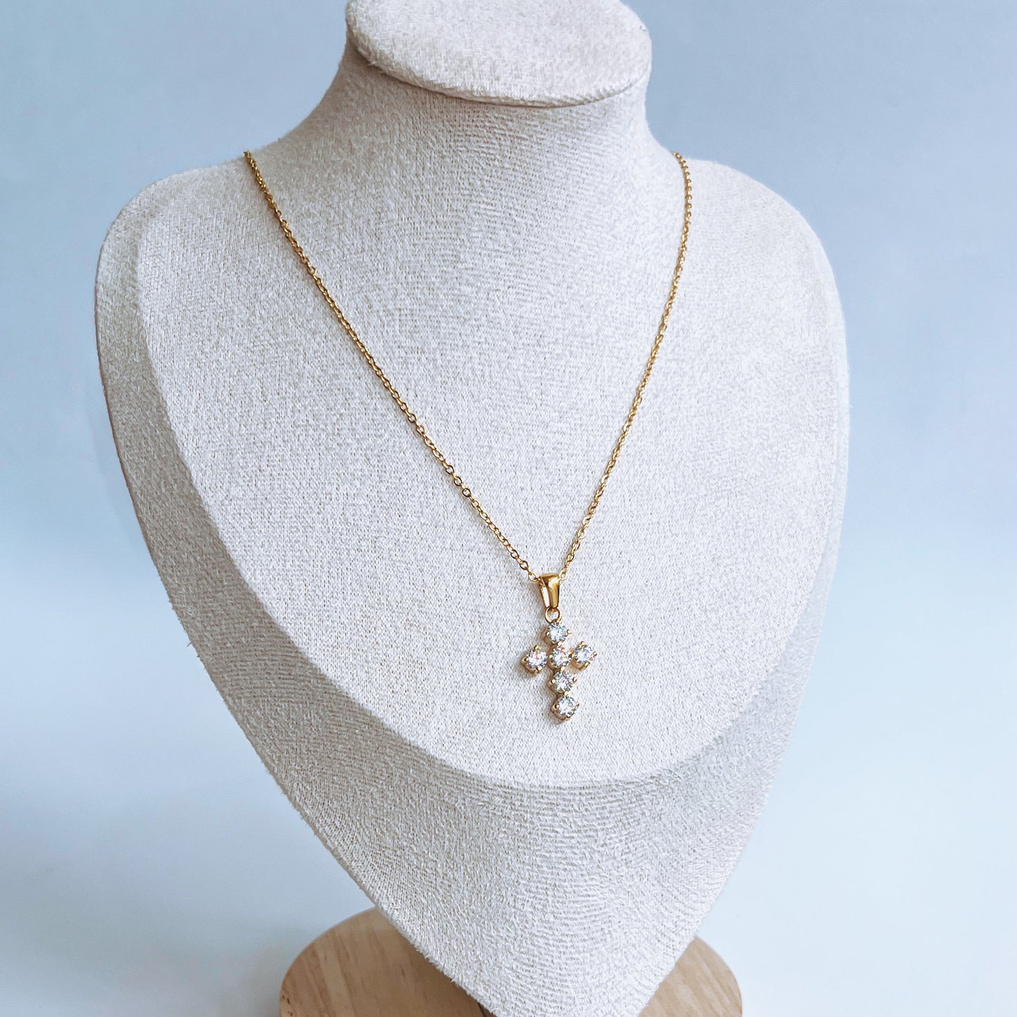 stainless steel gold Cross Pendant Necklace with a diamond cross pendant on a mannequin bust against a light background
