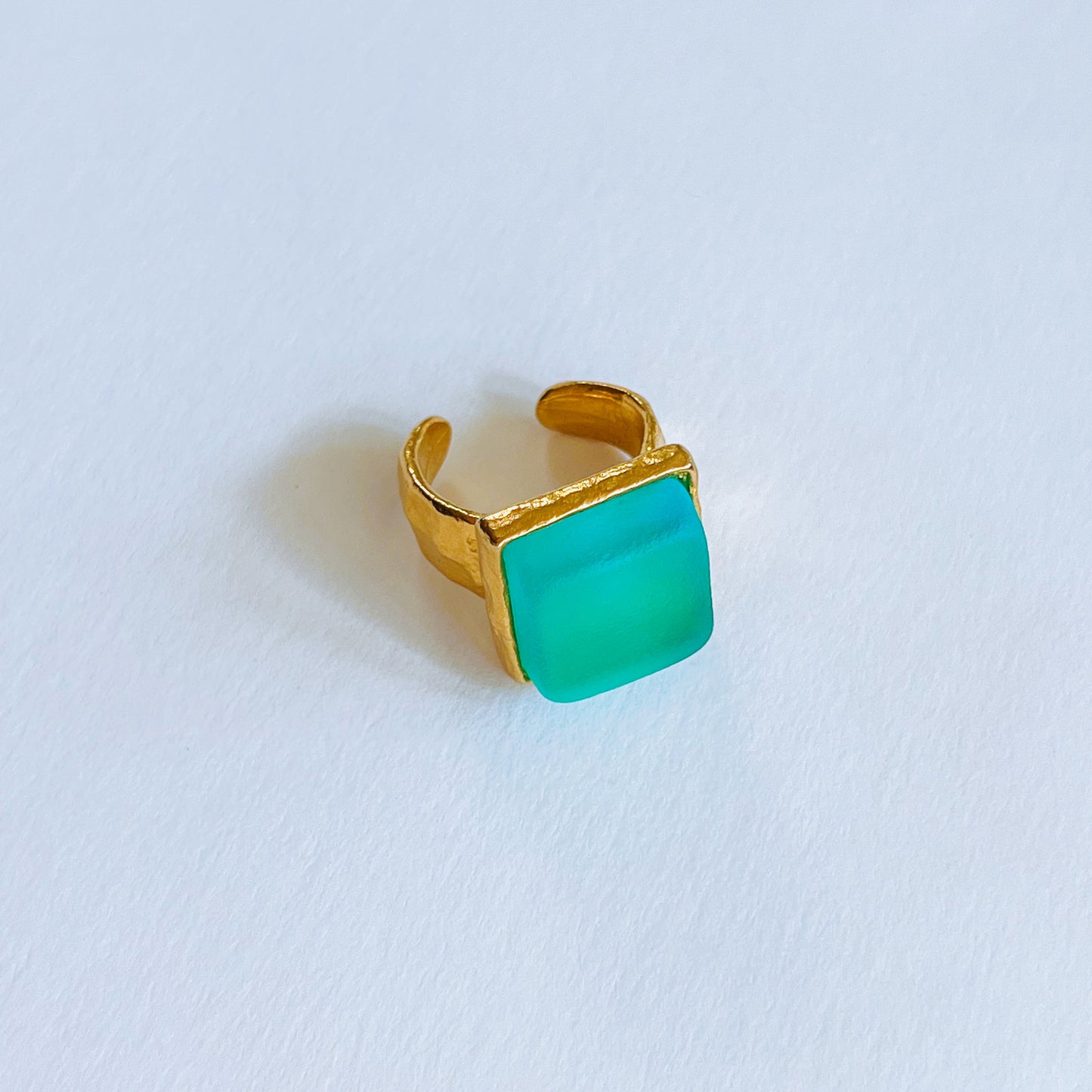 Cube Ring Gold - Aqua Gold ring with a square bright blue sea glass on a light background