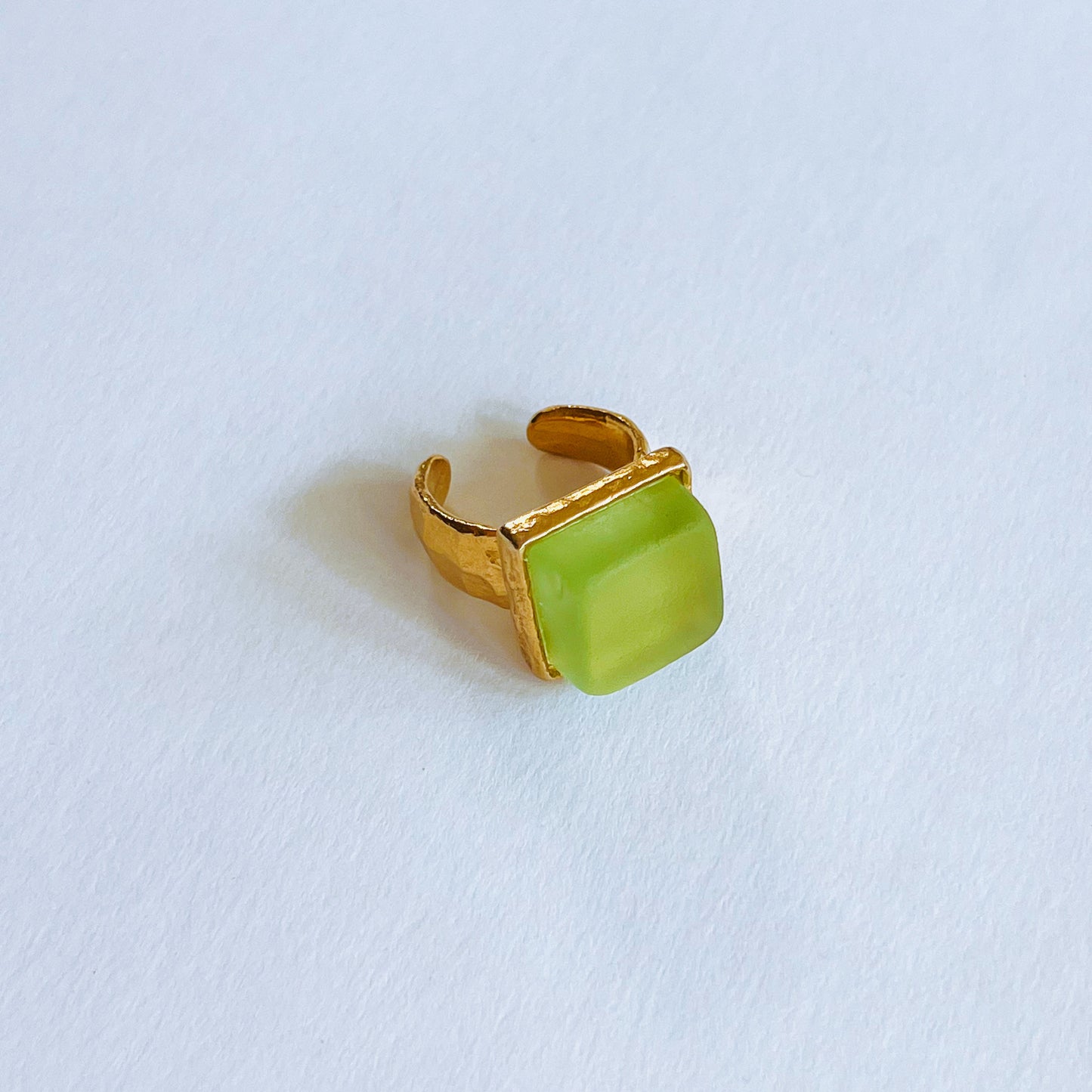 Cube Ring Gold - Lime Gold ring with a green stone on a light background