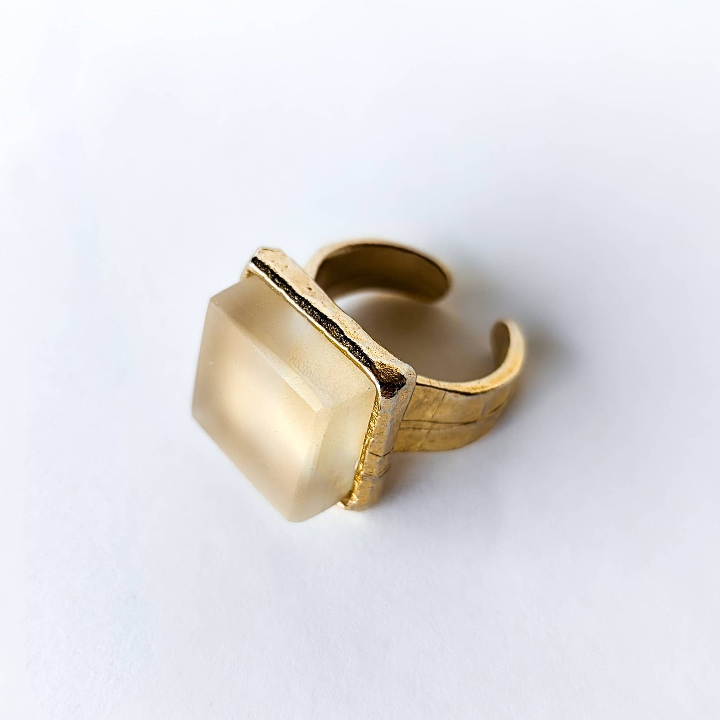 Gold recycled glass cube statement ring with a geometric design on a white background