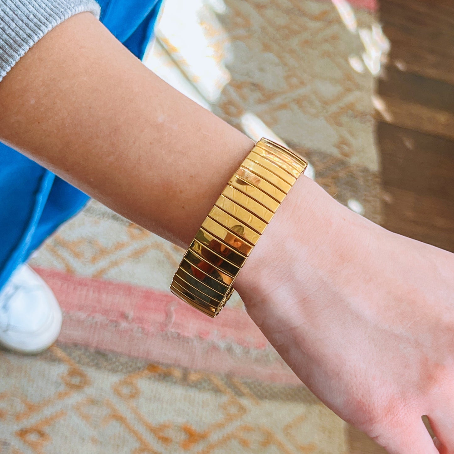 Gold Elastic Bracelet on a wrist with a blurred background