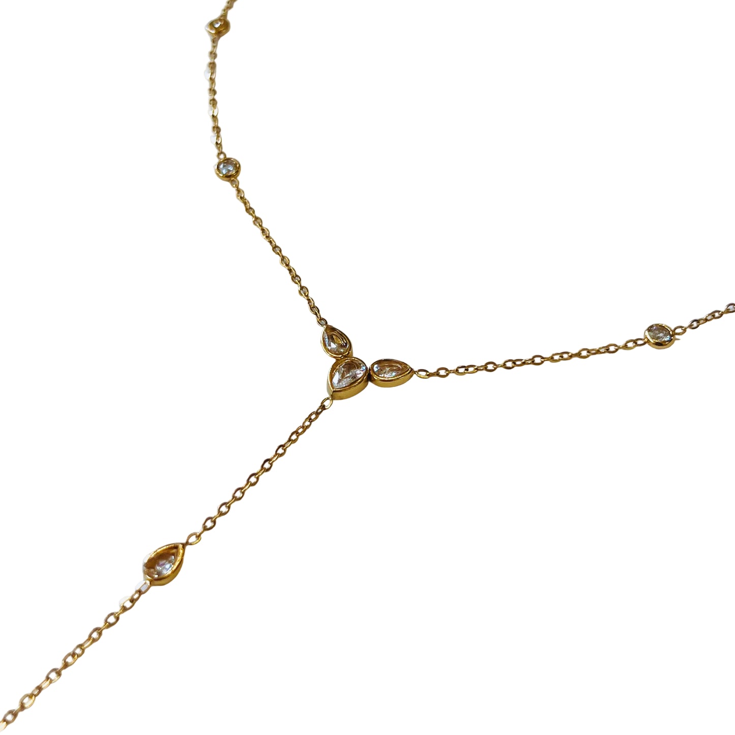 Gold necklace y shaped with small gemstone pendants on a light background