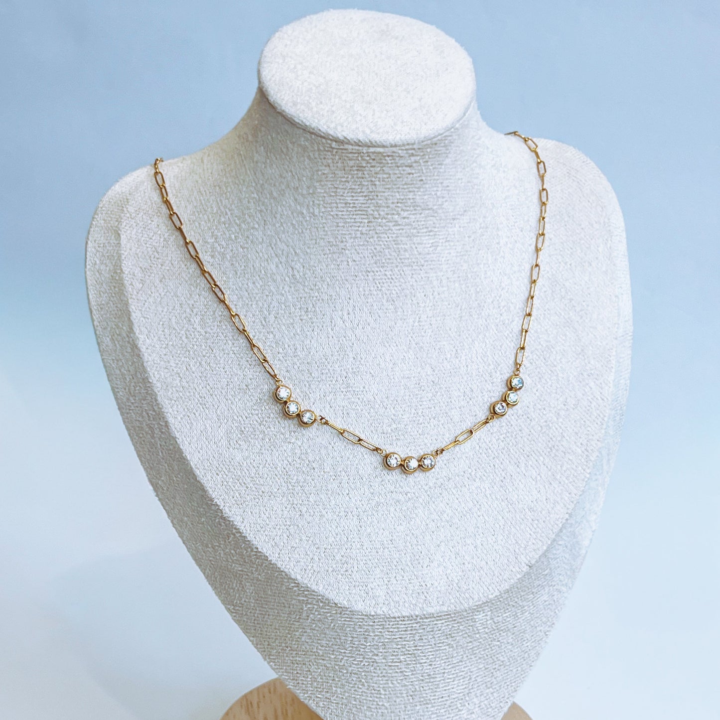 Gold Trio Necklace Gold chain necklace on a white mannequin bust with a light background 