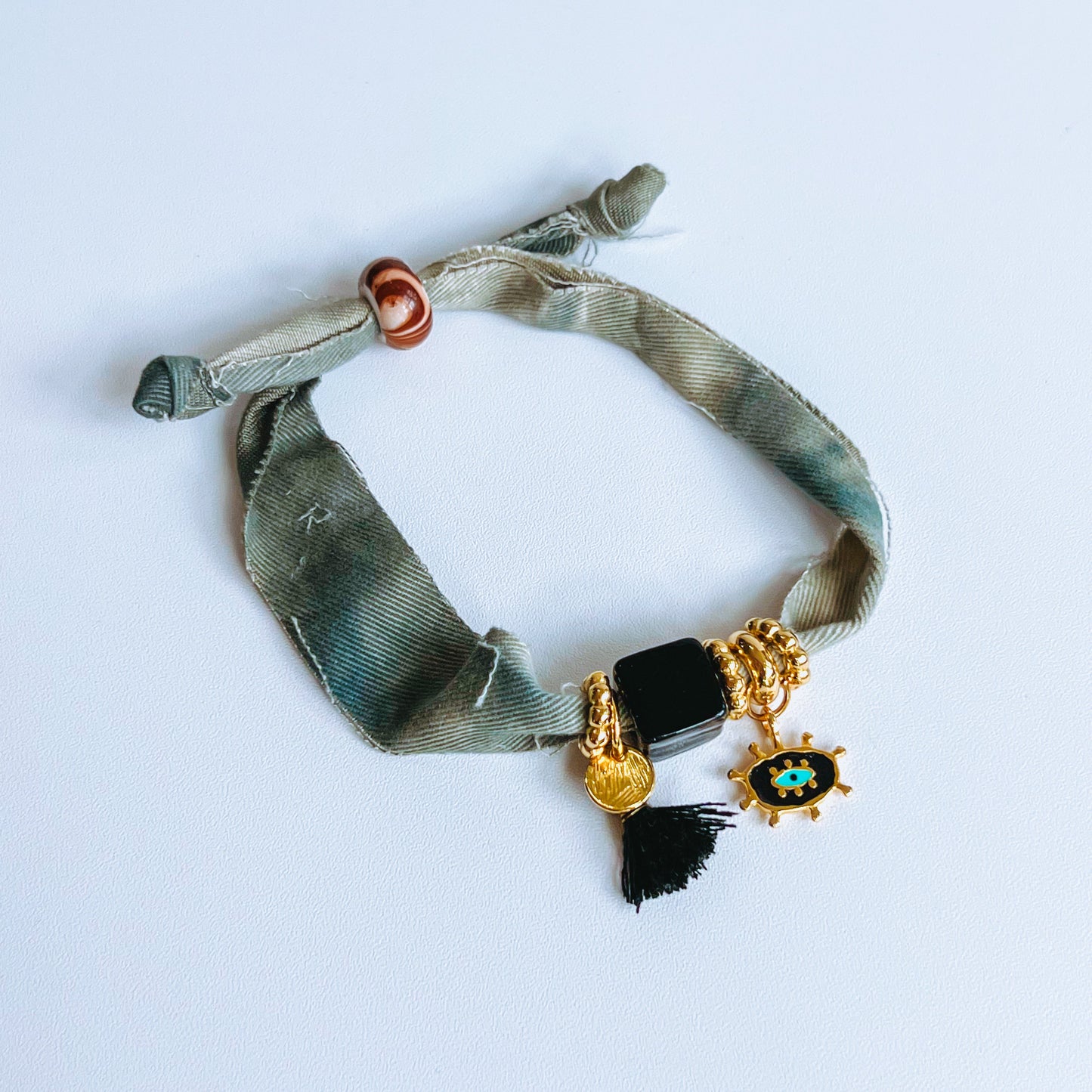 Gold and Black Denim Bracelet denim fabric Bracelet with evil eye charm on a light background