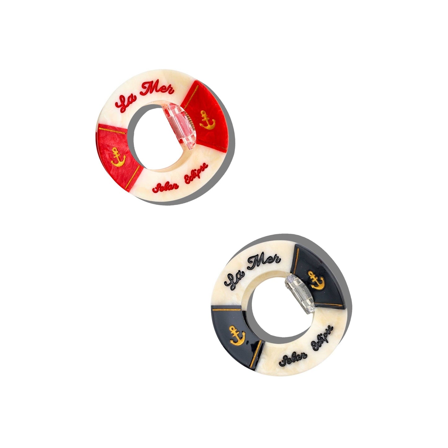 Two Hand- painted, one red and white one black and white, life buoy claw hair clip with 'La Mar' branding on a white background