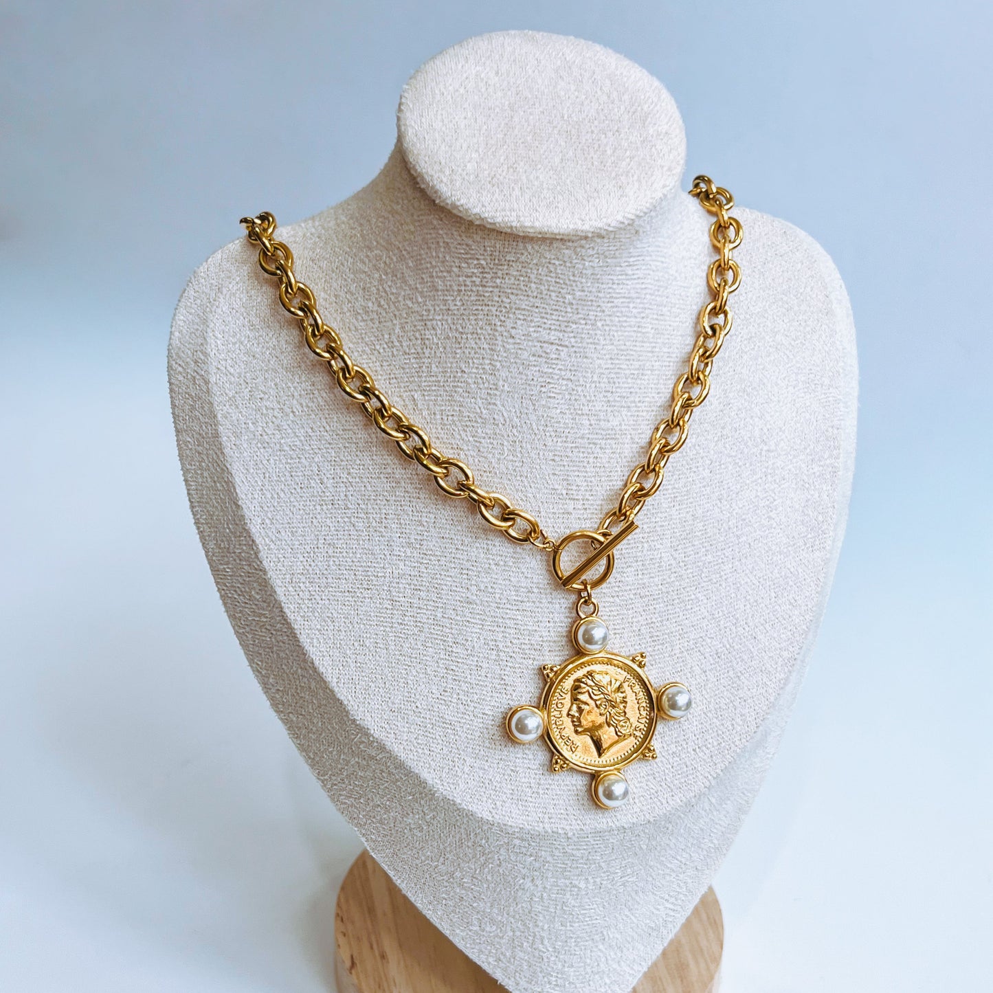 La Perla Coin Necklace with a coin pendant on a mannequin bust against a light background