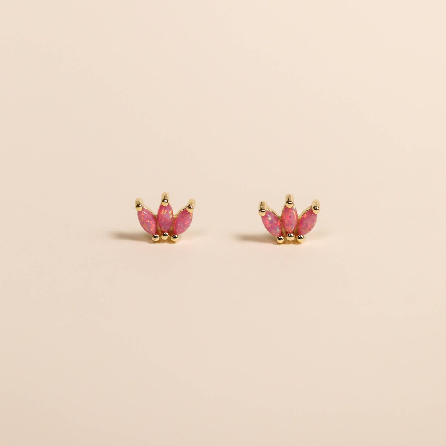 Opal Crown Gold Studs - Pink Pink gemstone earrings with gold crowns on a beige background