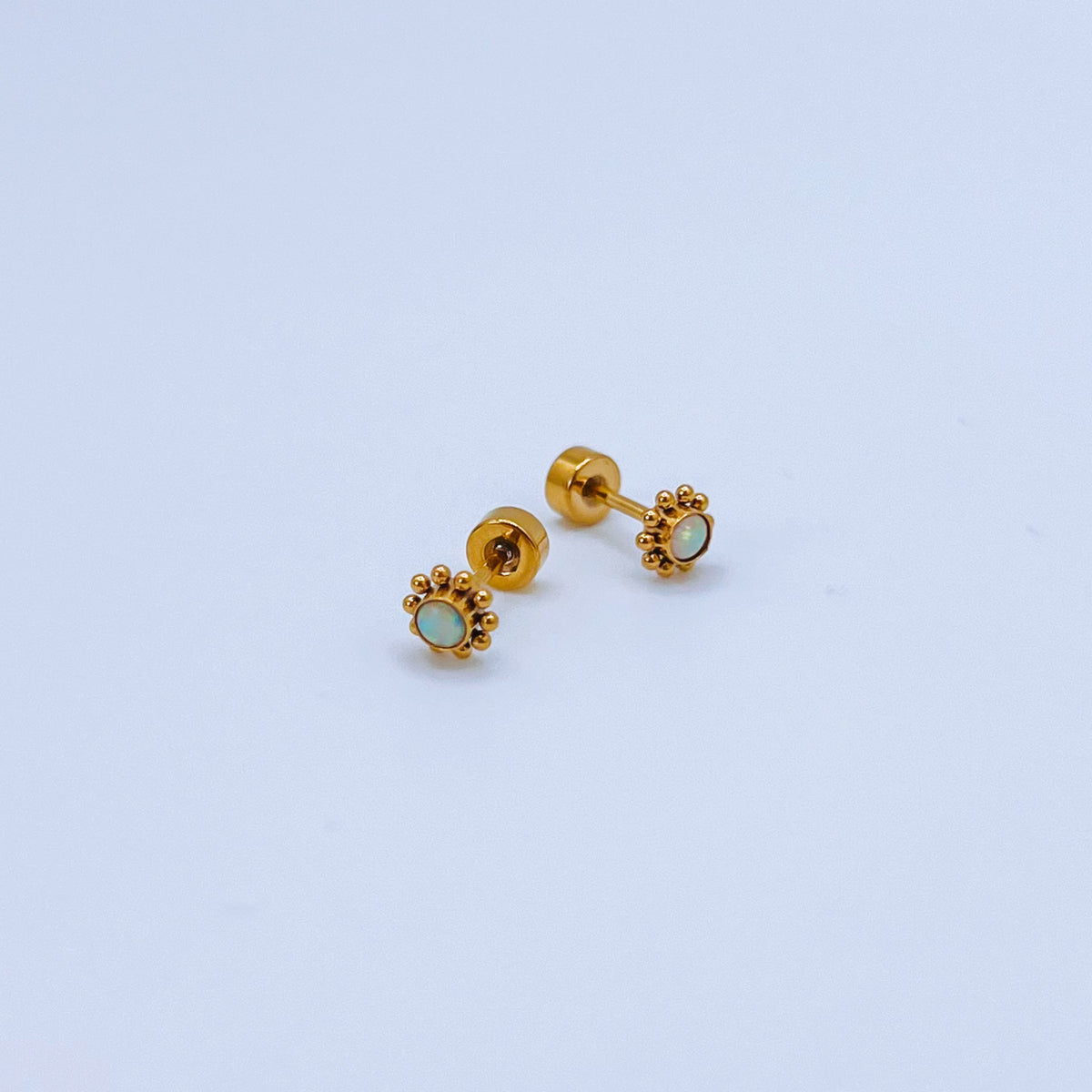 A pair of gold flower-shaped Opal Screwback Stud Earrings with light blue oval inlays