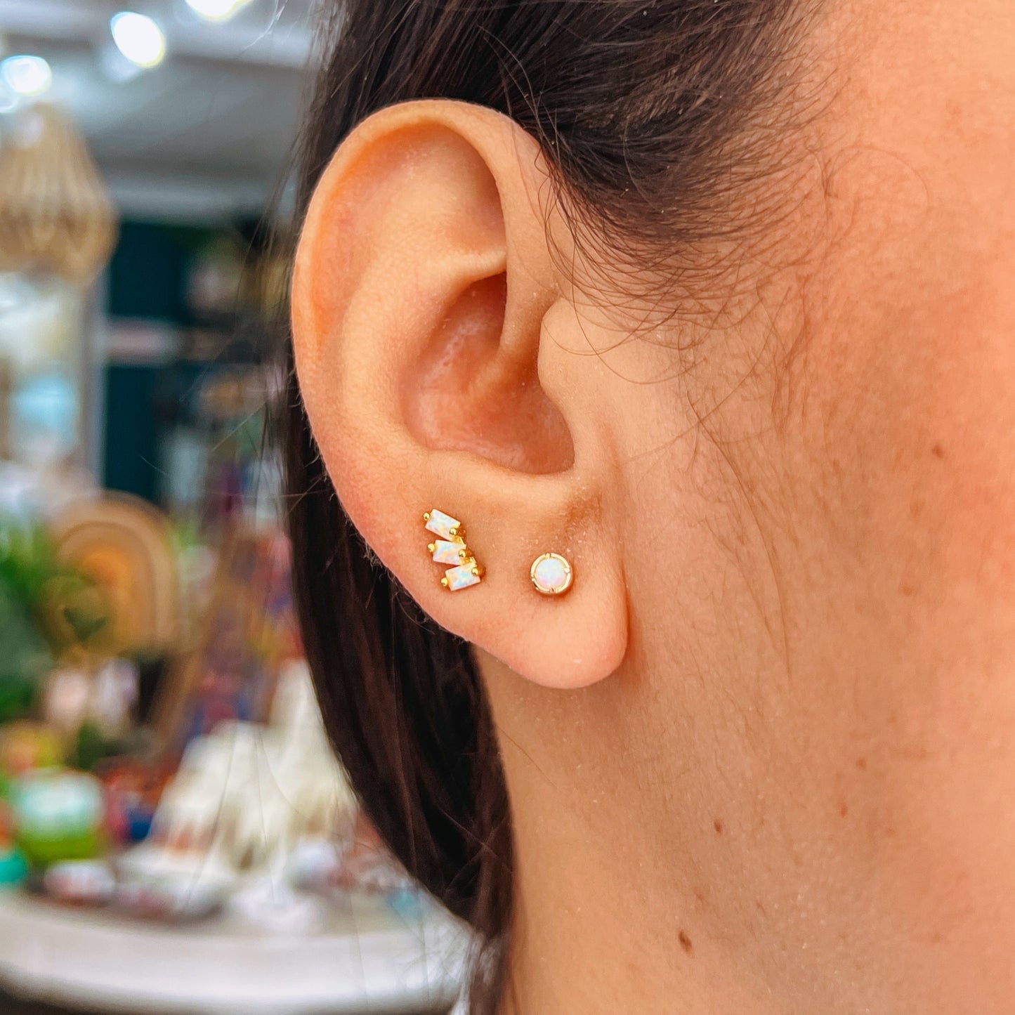 Simple Gold Stud - White Opal Close-up of an ear wearing gold and pearl stud earrings