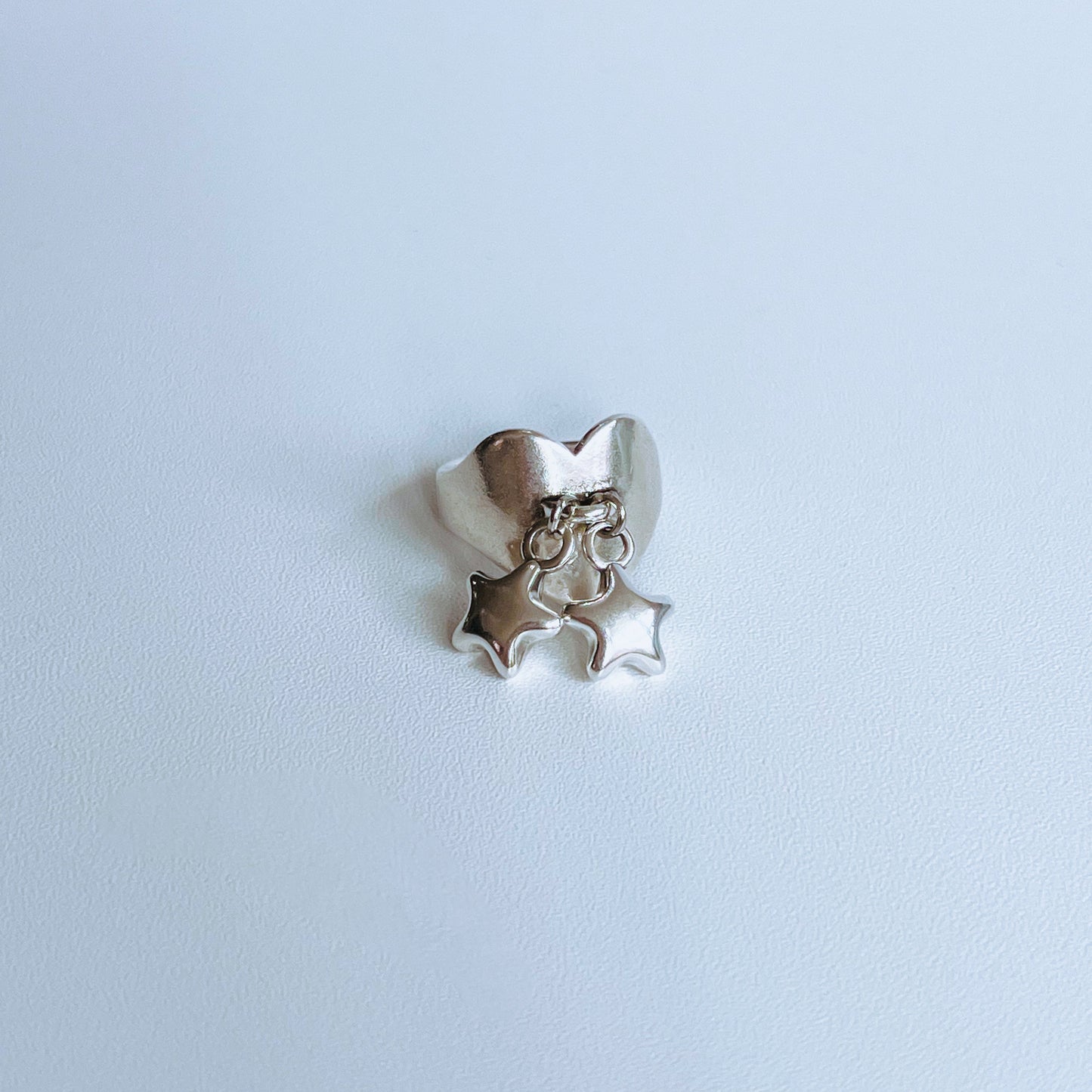 Stars Heart Ring - Silver ring with star shaped charms on a light background