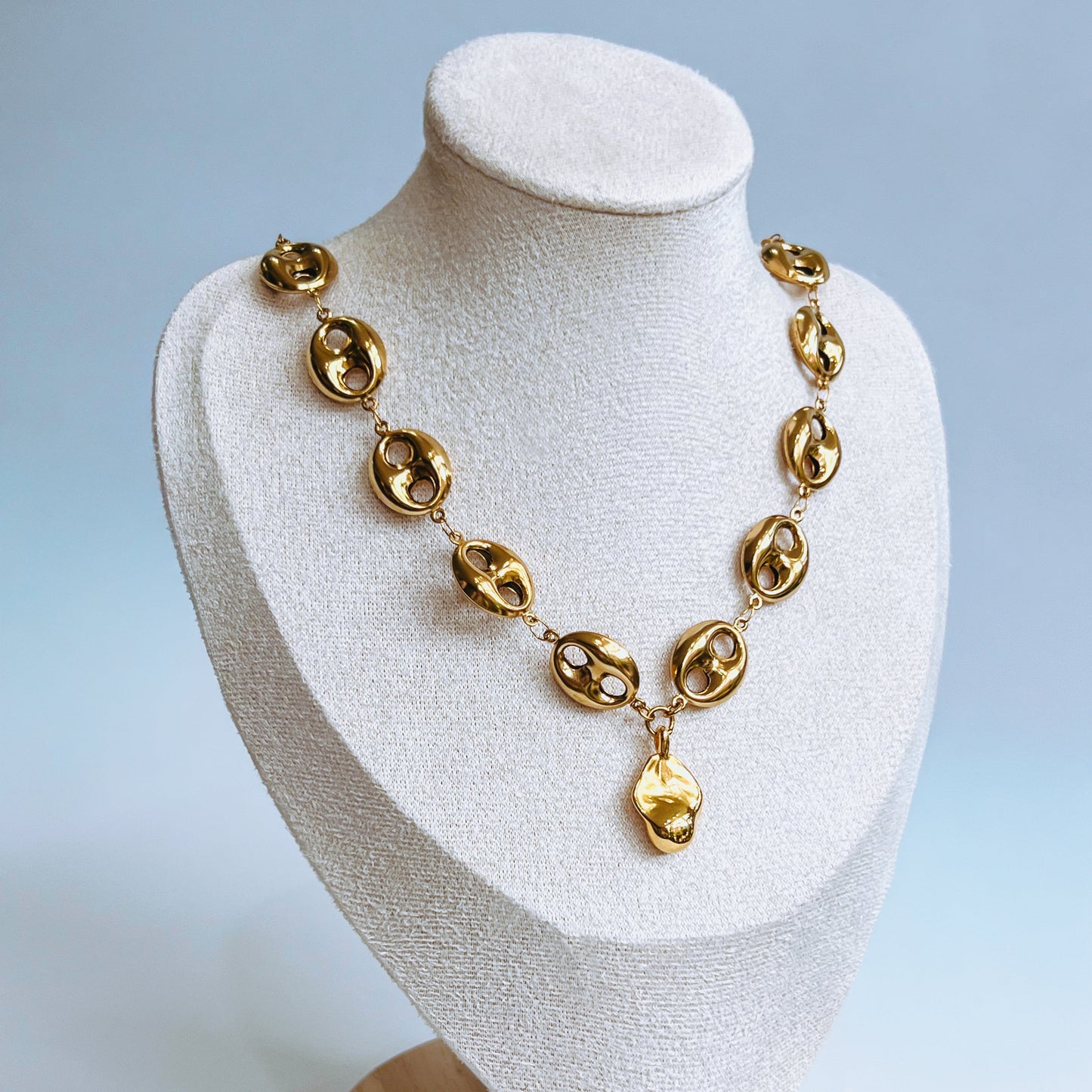 Theta Chunky Necklace -  Gold necklace on a white mannequin bust with a light background