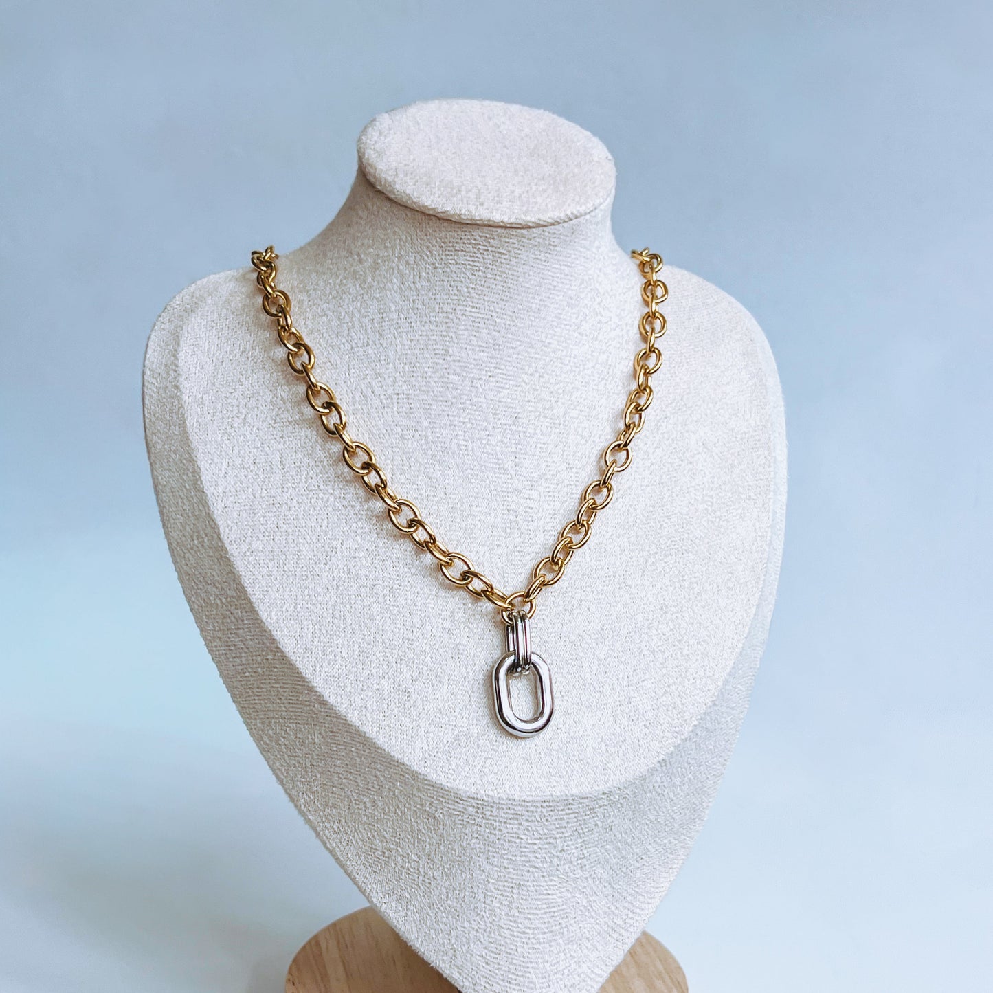mixed metal Two Tone Chain Necklace Gold chain necklace with silver pendant on a white mannequin bust with a light background