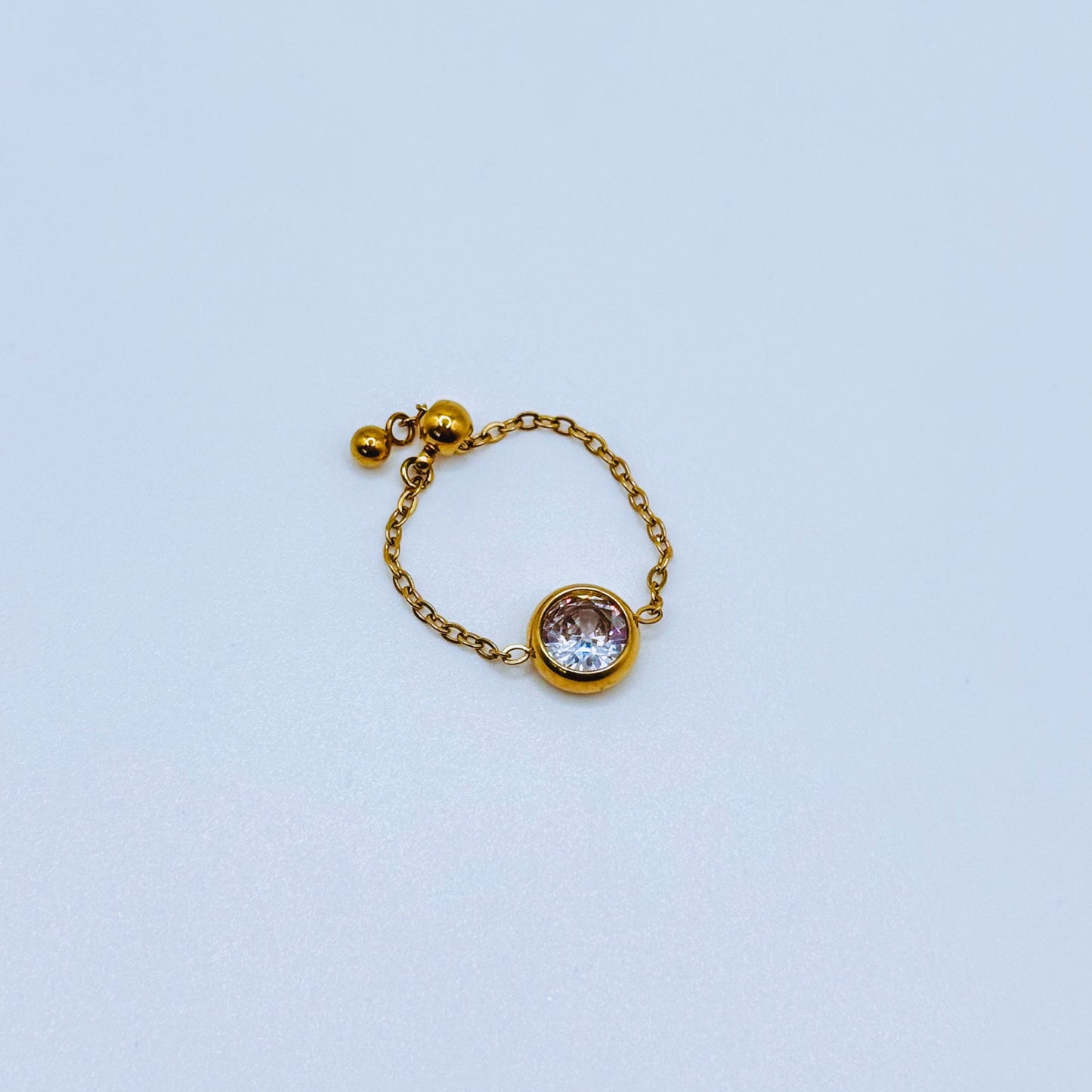 Gold ring with a gemstone on a light blue background