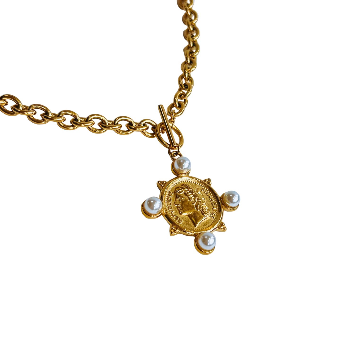 Gold necklace with a  gold coin pendant surrounded by small pearls on a white background